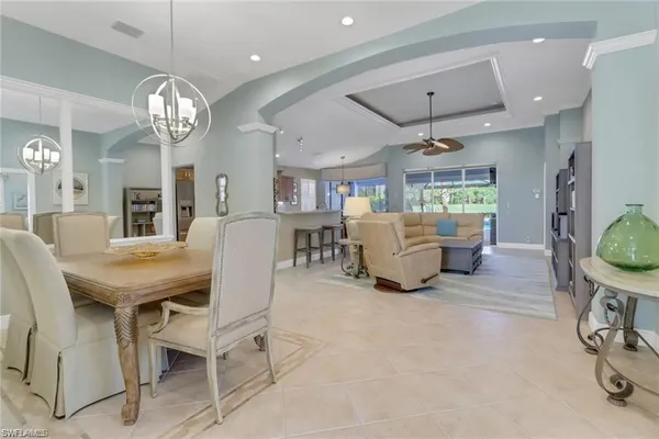 a living room with furniture a chandelier and a dining table