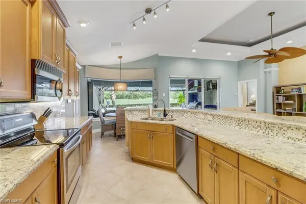 a kitchen with stainless steel appliances granite countertop sink stove and refrigerator