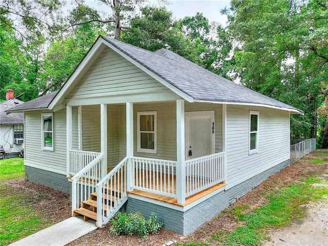 a porch with a bench next to a yard