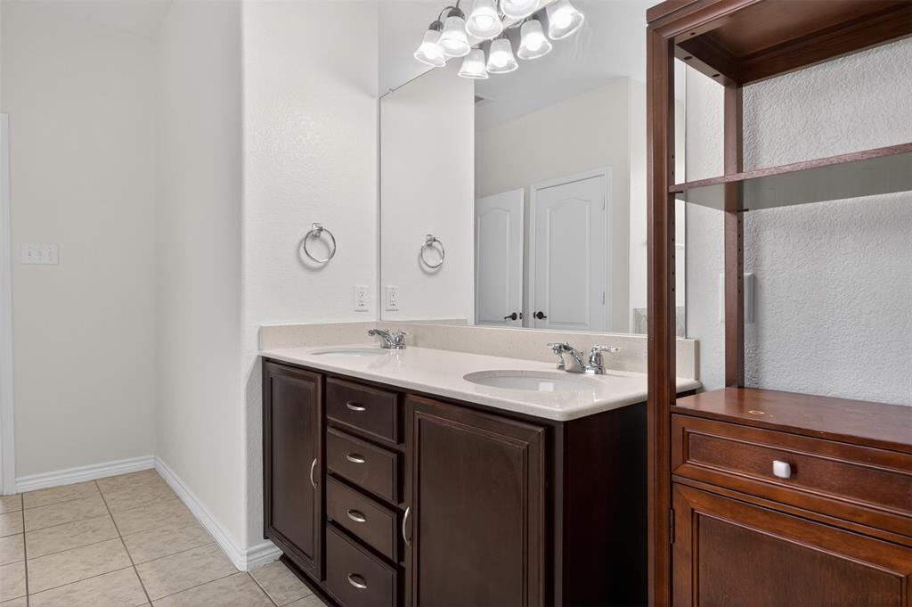 8728 Maple Ridge Trail Fort Worth, TX 76244 - Photo 24 of 40 Bathroom featuring dual dark wood vanities with light countertops and undermount sinks