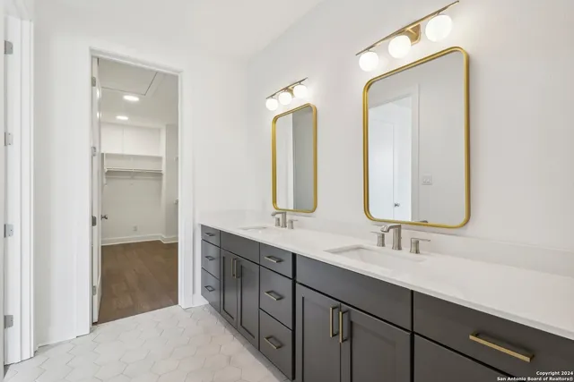 a bathroom with double vanity sinks and a mirror