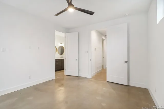 an empty room with a ceiling fan and window