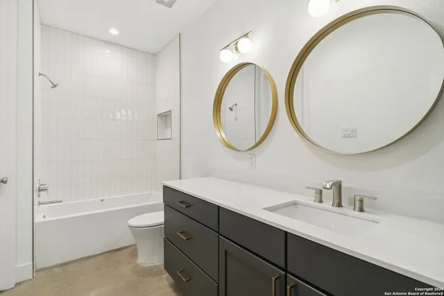 a large kitchen with granite countertop a sink a counter top space appliances and cabinets