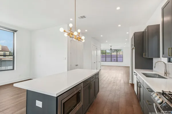 a large kitchen with kitchen island a sink stainless steel appliances and cabinets