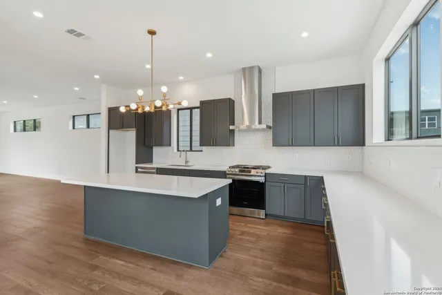 a kitchen with a sink dishwasher a stove and a refrigerator with wooden floor