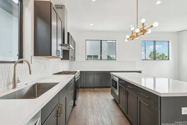 a kitchen with a refrigerator a sink and wooden floor