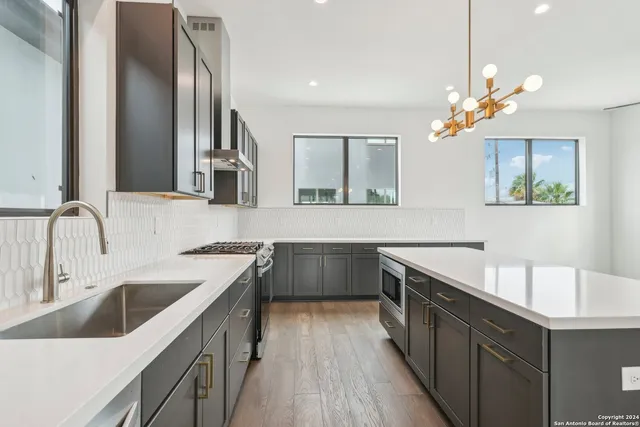 a kitchen with a refrigerator a sink and wooden floor