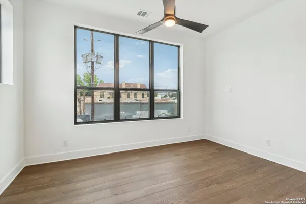 a view of empty room with wooden floor and windows