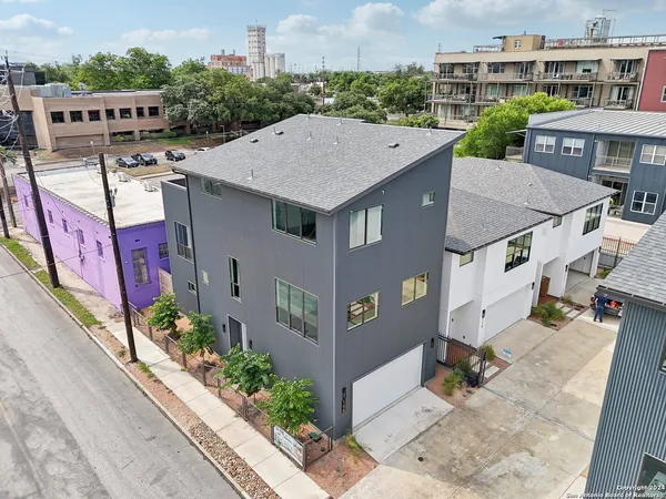 an aerial view of a house with a yard and large tree