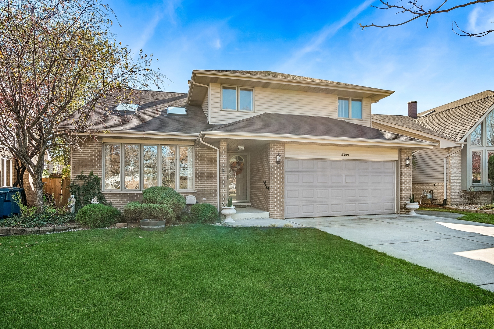 a front view of a house with a yard and garage