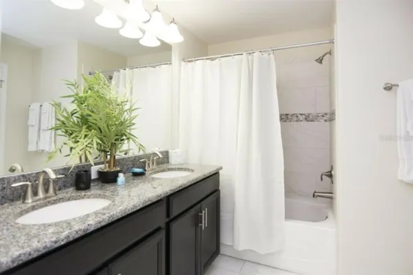 a bathroom with a granite countertop sink a mirror and a shower