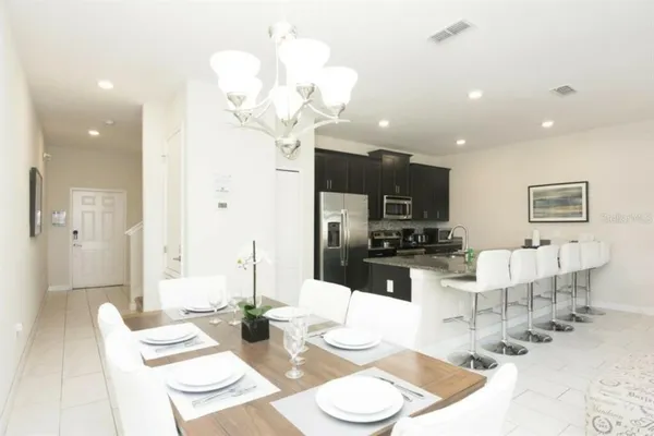 a kitchen with stainless steel appliances kitchen island granite countertop a table and chairs in it