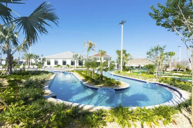a patio with table and chairs with potted plants and palm trees