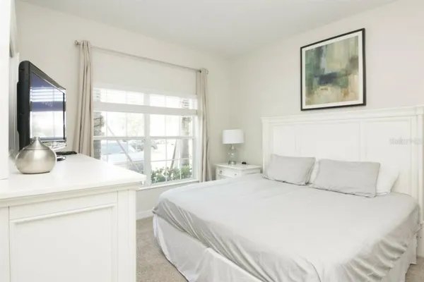 a bedroom with a bed and a large window