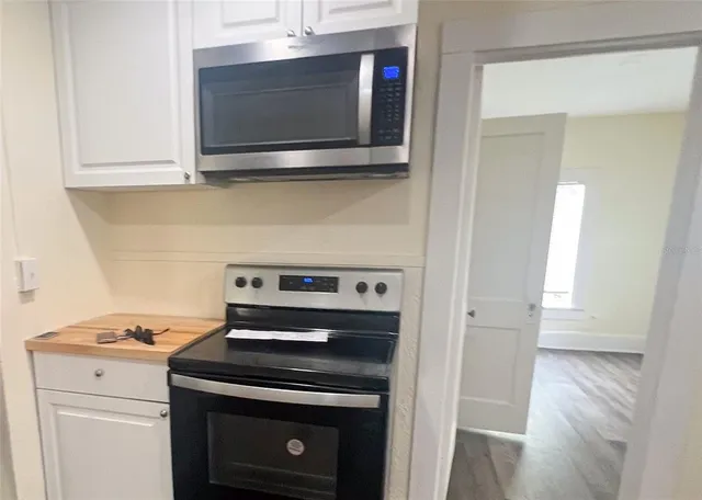 a view of a hallway with wooden floor and stairs
