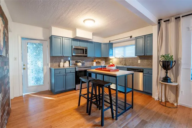 a kitchen with stainless steel appliances granite countertop a sink stove and microwave