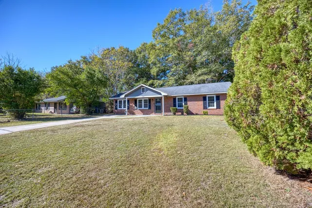 a front view of a house with yard and green space