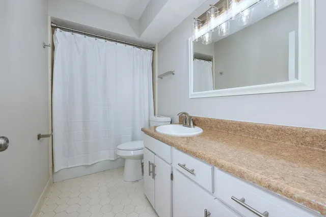 a backyard of a house with large trees and wooden fence