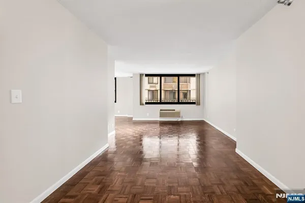 a view of a big room with wooden floor and windows