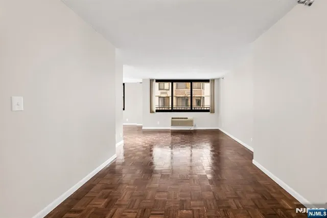 a view of a big room with wooden floor and windows