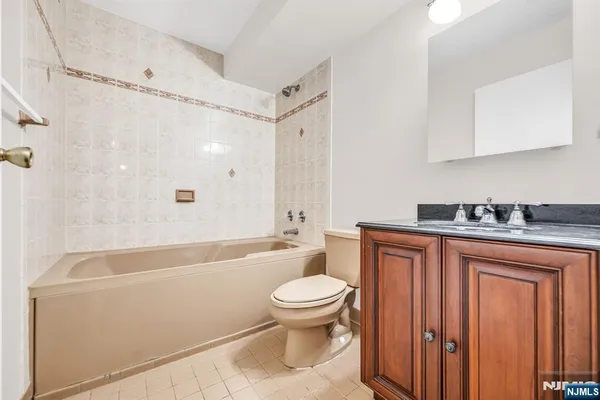 a bathroom with a granite countertop sink a toilet and shower