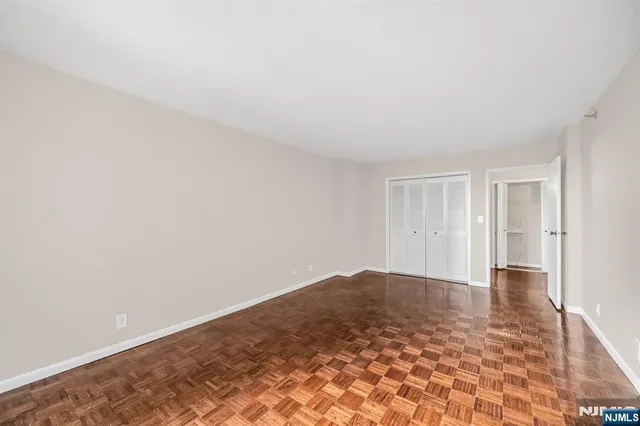 a view of empty room with wooden floor