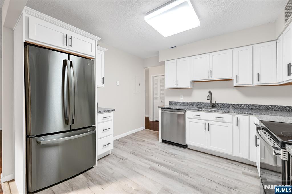 326 Prospect Avenue, Unit 6J Hackensack, NJ 07601 - Photo 2 of 18 a kitchen with a refrigerator stove and sink