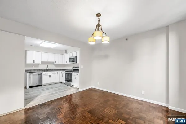 a kitchen with a refrigerator and white cabinets