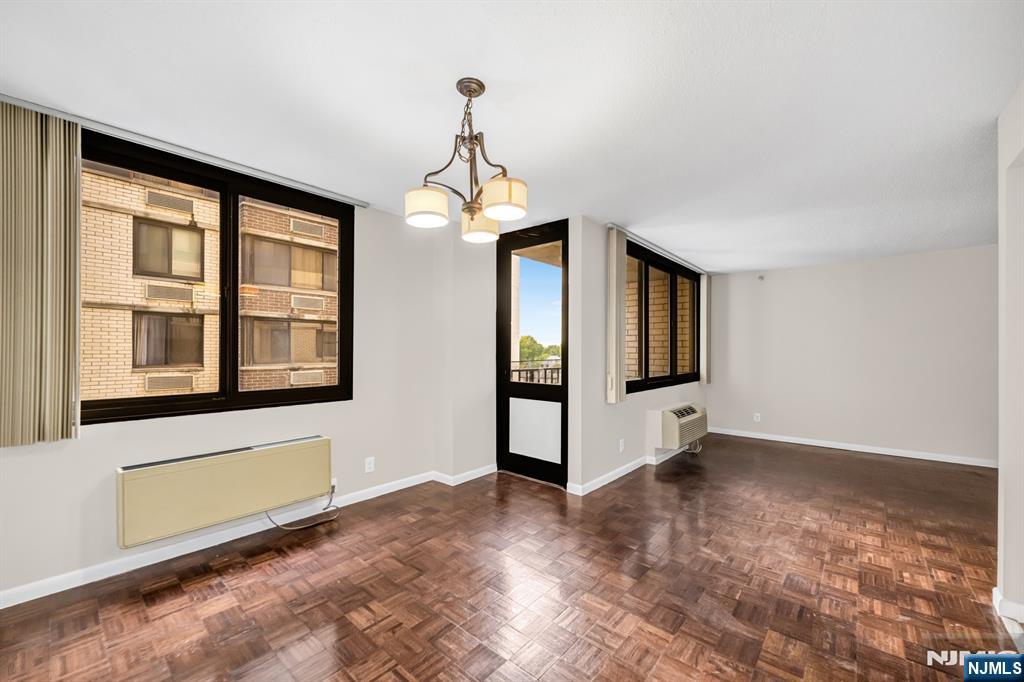 326 Prospect Avenue, Unit 6J Hackensack, NJ 07601 - Photo 7 of 18 a view of an empty room with window and wooden floor