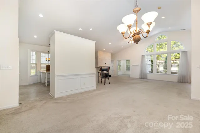 a view of a livingroom with a chandelier furniture and windows