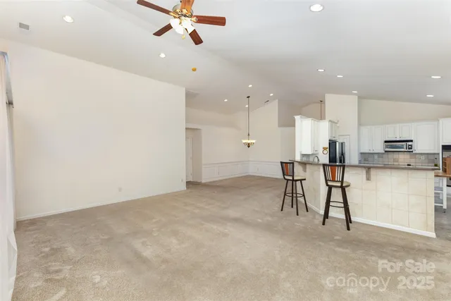 a view of kitchen with stainless steel appliances refrigerator stove microwave and cabinets