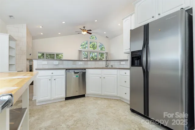 a kitchen with white cabinets stainless steel appliances and a counter space