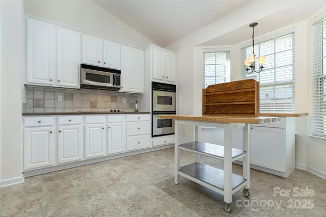 a kitchen with white cabinets and appliances
