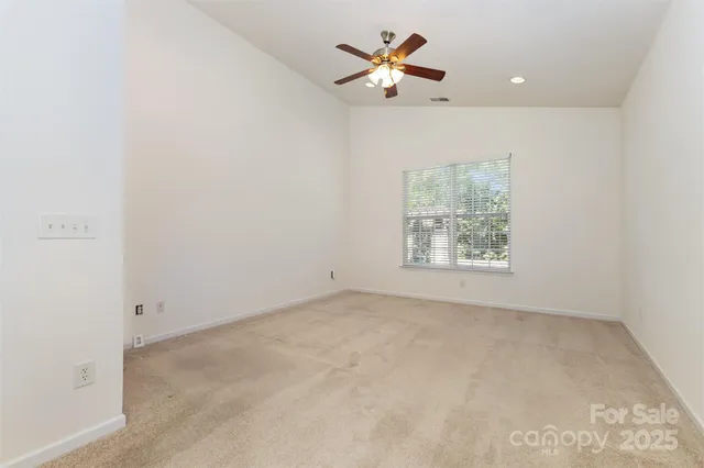 an empty room with a window and a fan