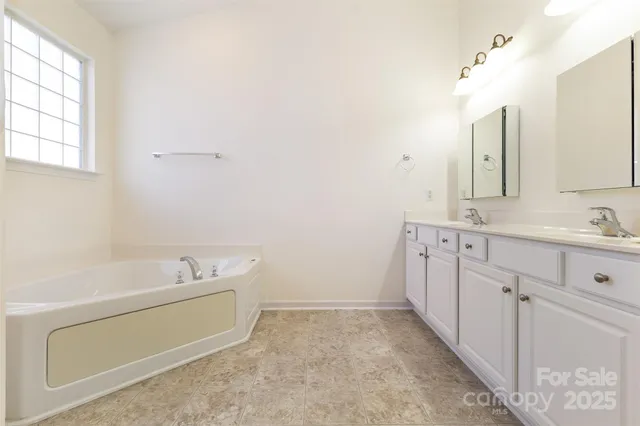 a bathroom with a tub sink and mirror