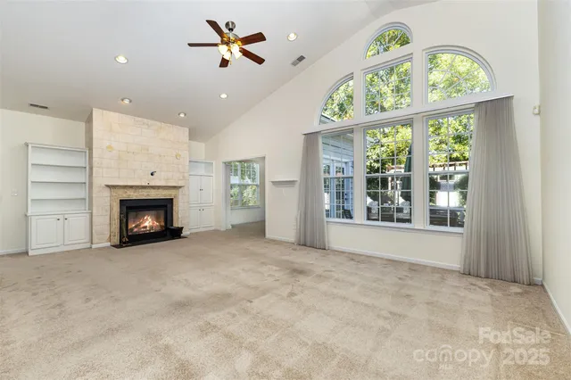 a view of an empty room with a window and fireplace