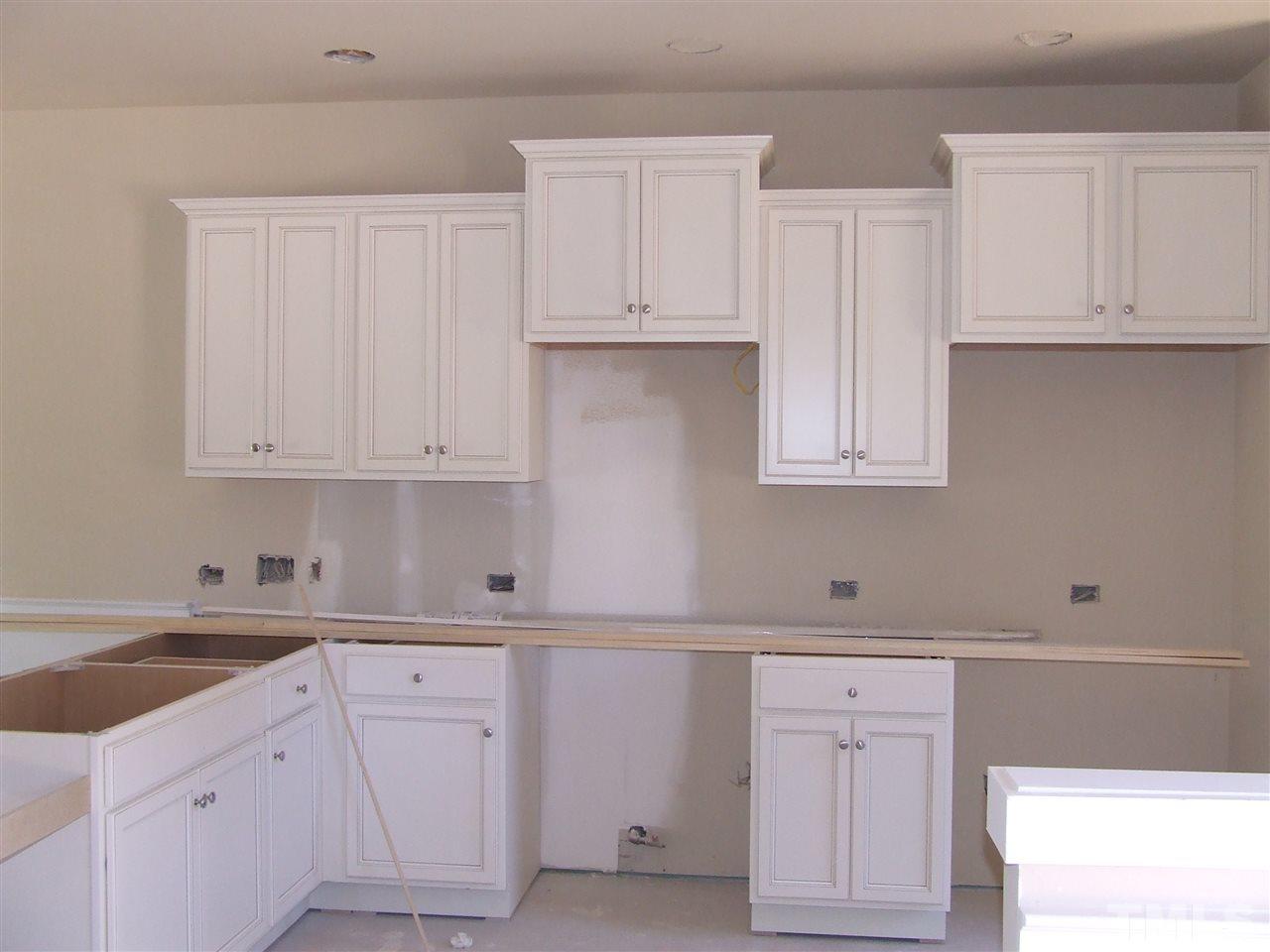 7912 Allscott Way Raleigh, NC 27612 - Photo 2 of 14 Cream/linen cabinets in kitchen, will have granite tops and tile back splash as well as SS appliances and hardwood floors. Will be ready for and end of year move in!