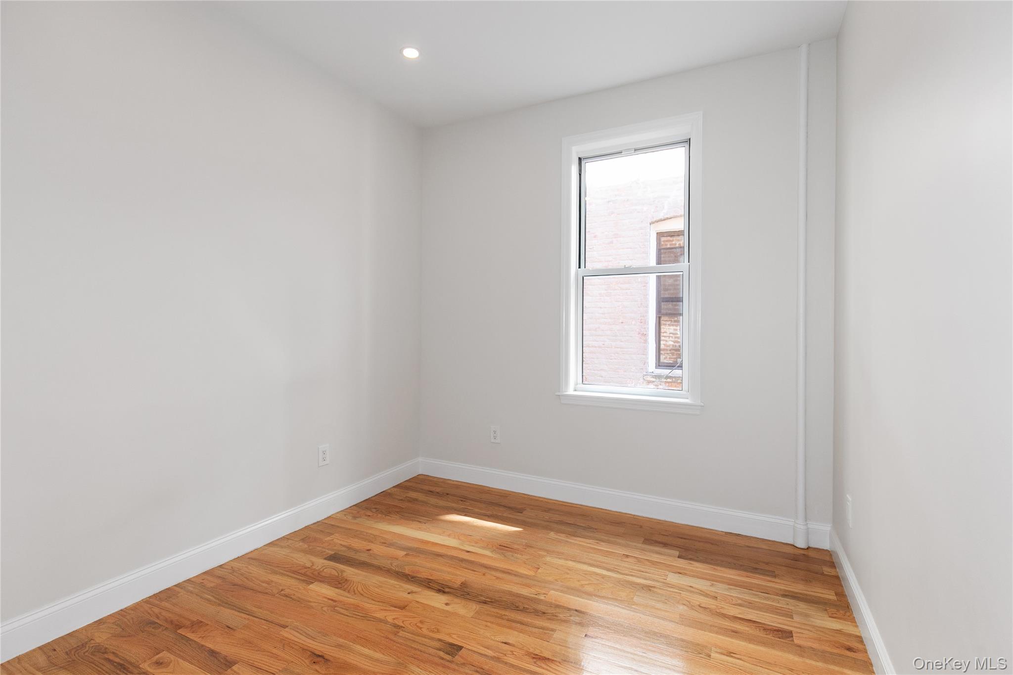 104-44 42nd Avenue Queens, NY 11368 - Photo 11 of 16 a view of empty room with wooden floor and fan