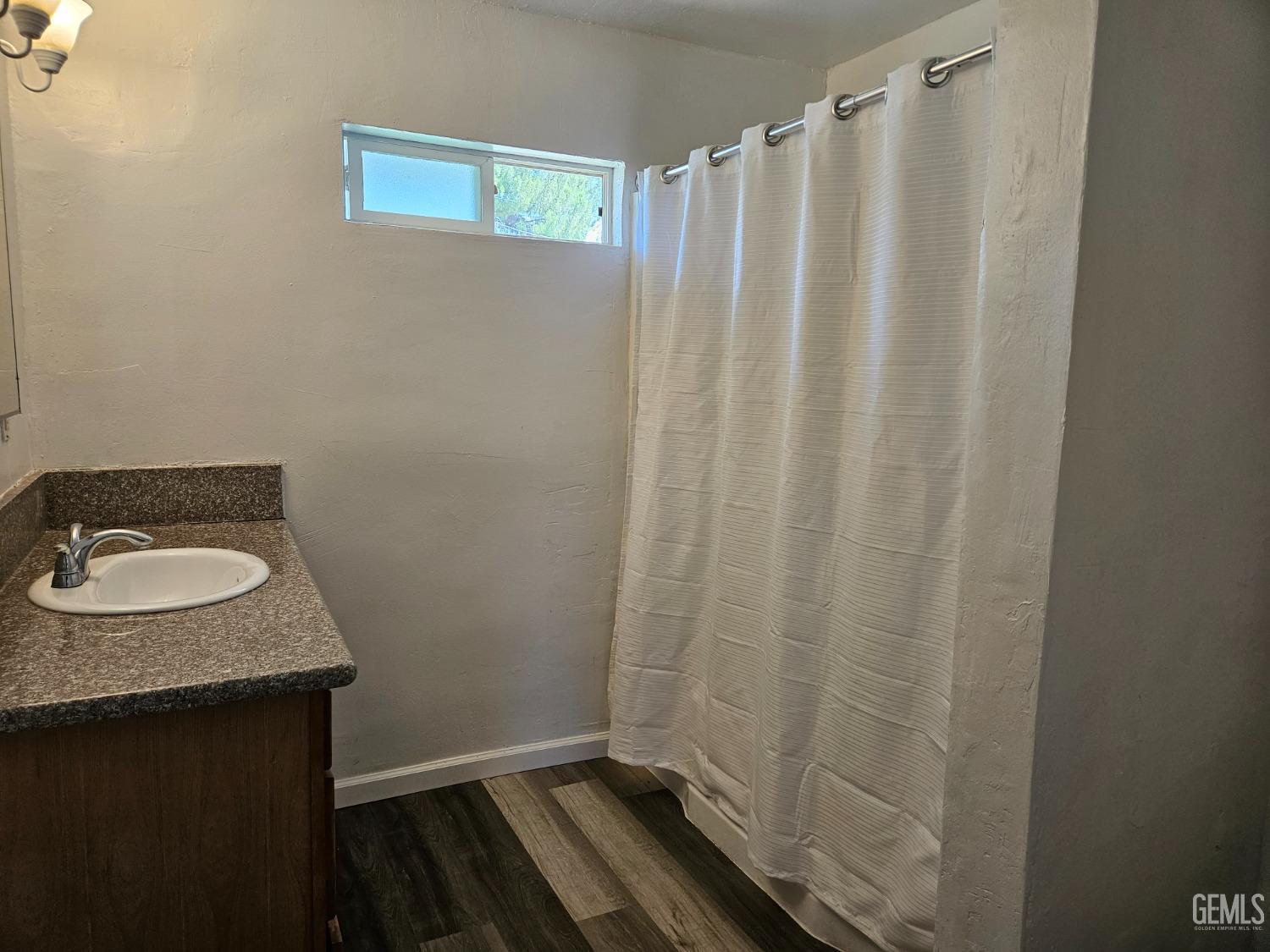 Undisclosed Address Bakersfield, CA 93307 - Photo 13 of 17 a bathroom with a granite countertop sink and a mirror