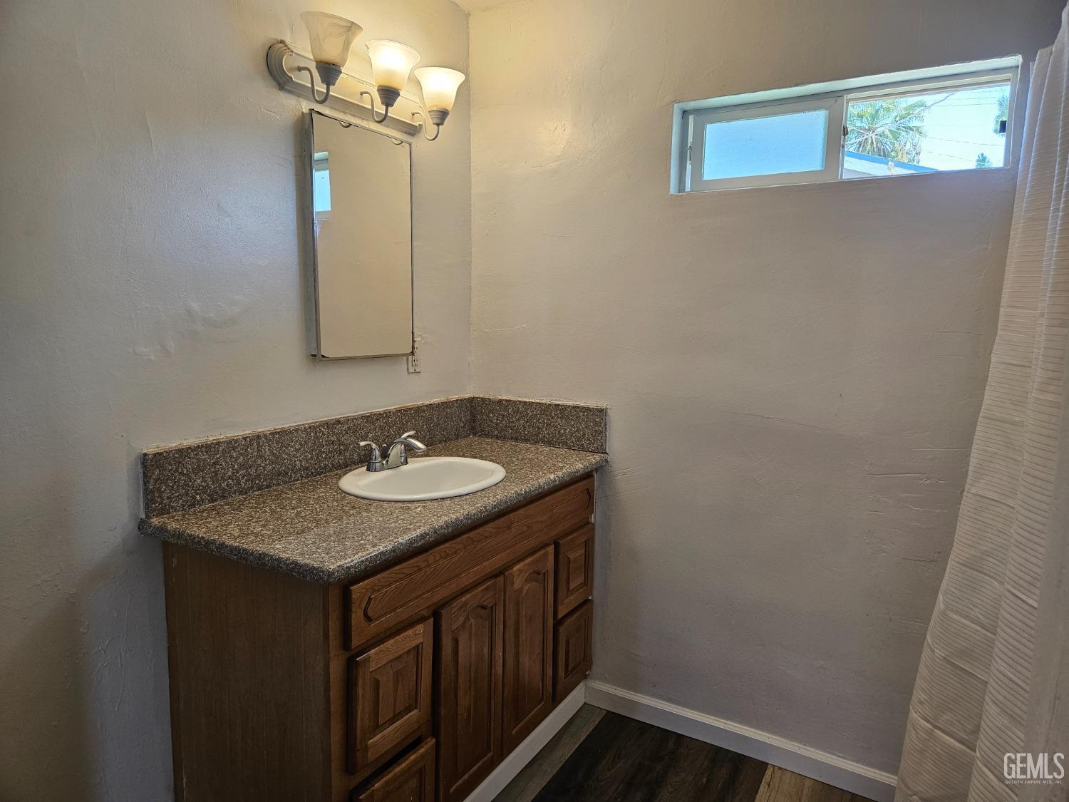 Undisclosed Address Bakersfield, CA 93307 - Photo 14 of 17 a bathroom with a granite countertop sink and a mirror