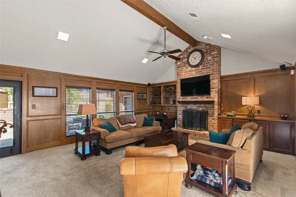 a living room with furniture a ceiling fan and a flat screen tv