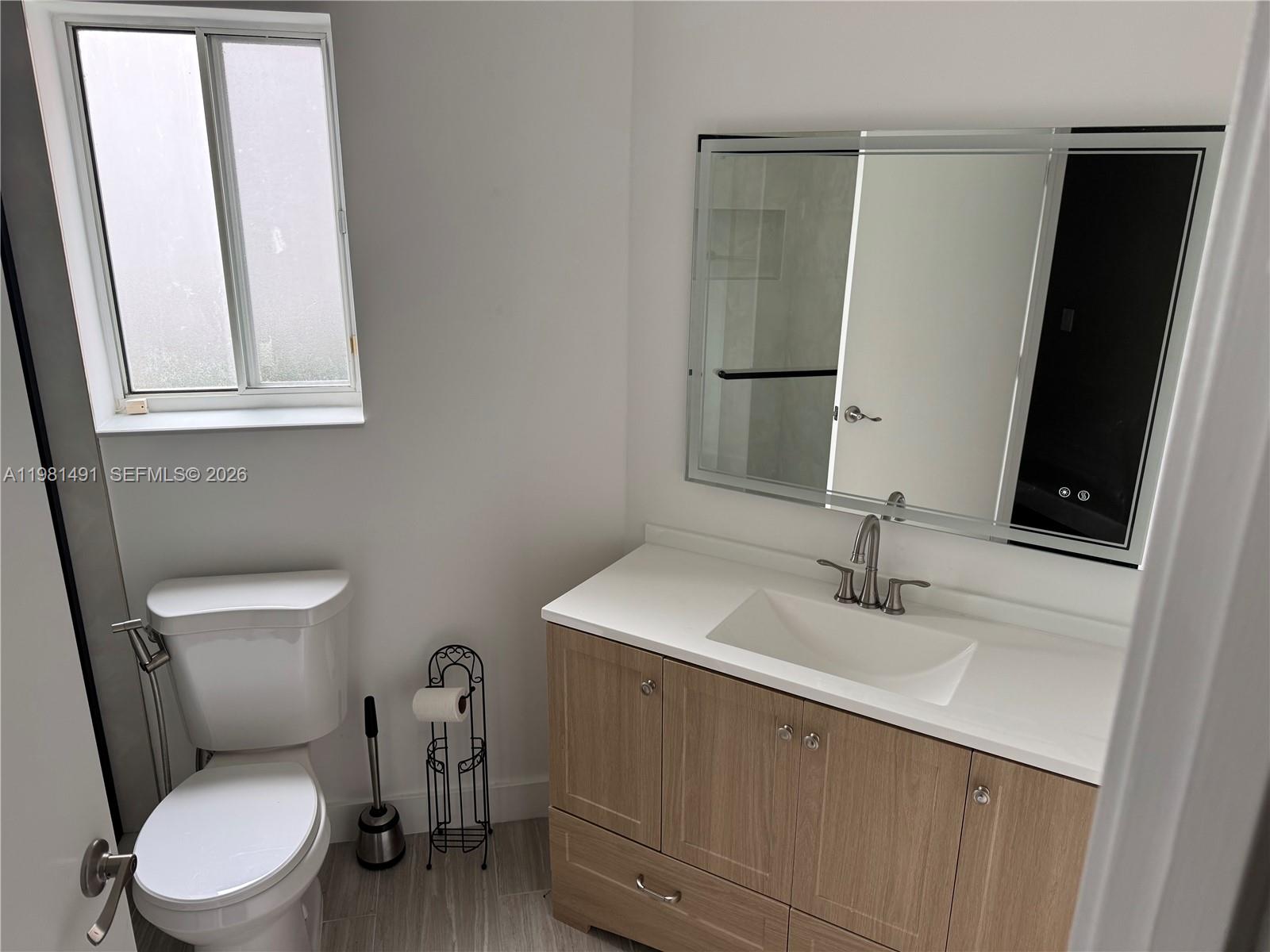 20478 Vía Marisa Boca Raton, FL 33498 - Photo 12 of 18 a bathroom with a toilet sink and mirror