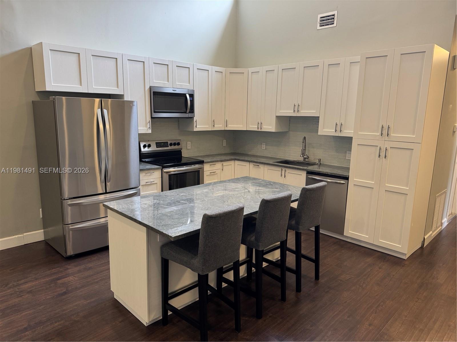 20478 Vía Marisa Boca Raton, FL 33498 - Photo 3 of 18 a kitchen with stainless steel appliances a refrigerator a stove a sink a dining table and chairs