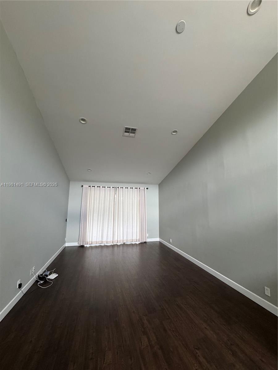 20478 Vía Marisa Boca Raton, FL 33498 - Photo 4 of 18 a view of an empty room with wooden floor and a window