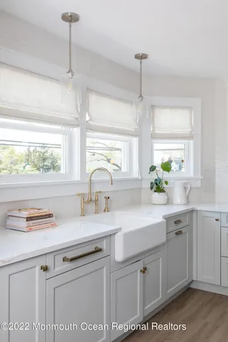 a kitchen with kitchen island white cabinets and white appliances