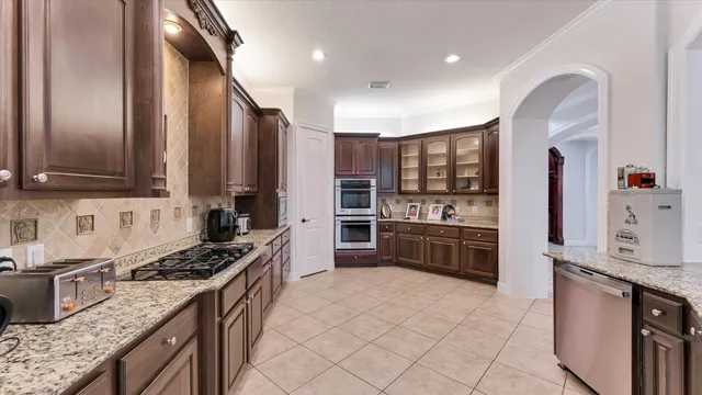 a kitchen with stainless steel appliances granite countertop a refrigerator and a sink