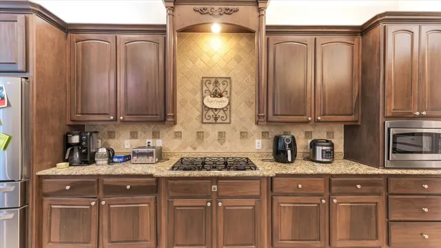 a kitchen with stainless steel appliances granite countertop a stove a sink and a microwave