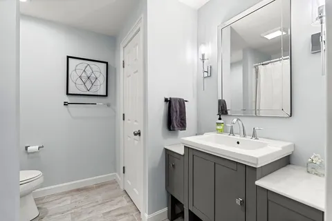 a bathroom with a toilet sink and mirror