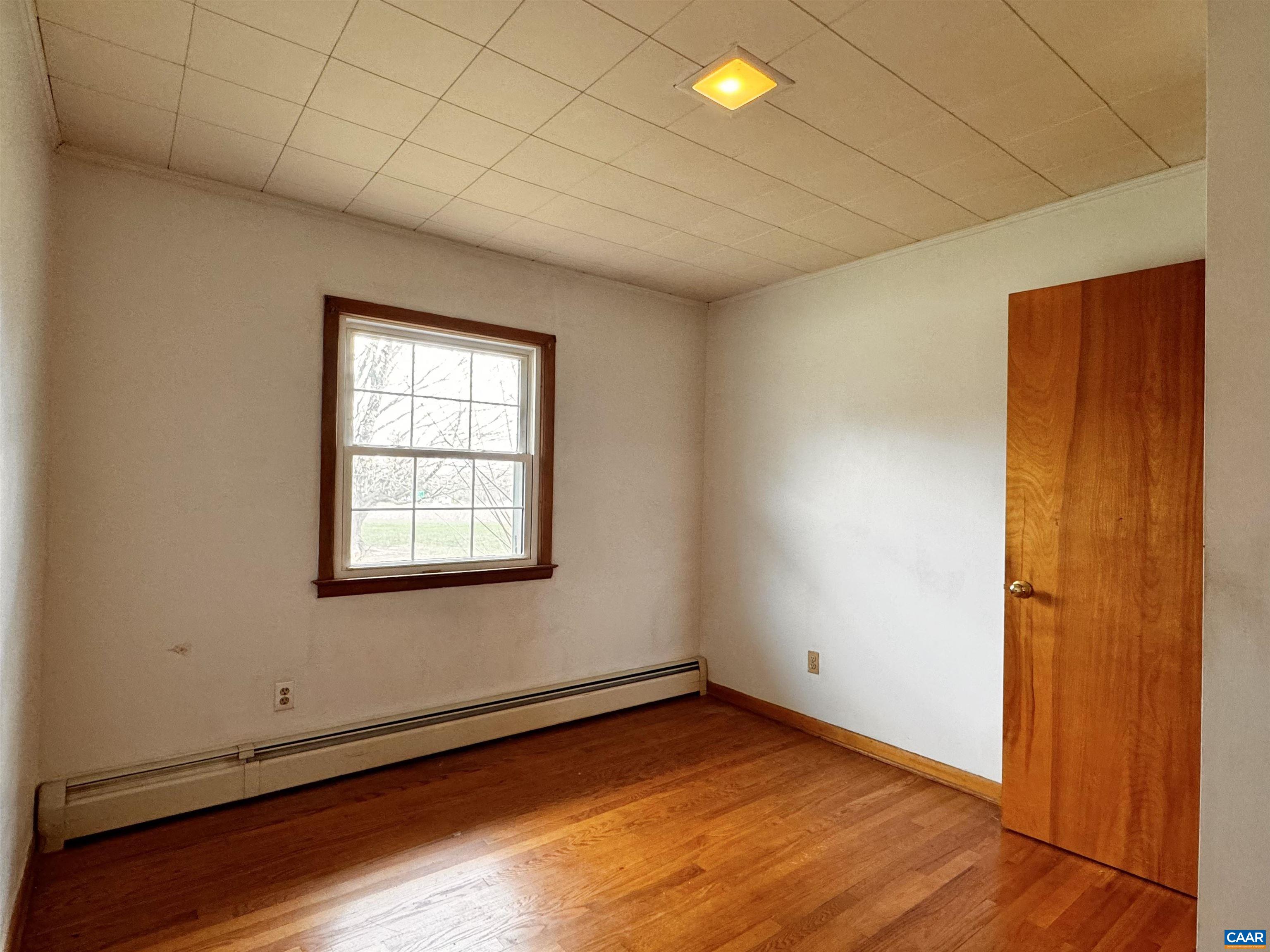 14540 Spotswood Trail Ruckersville, VA 22968 - Photo 11 of 42 an empty room with wooden floor and windows
