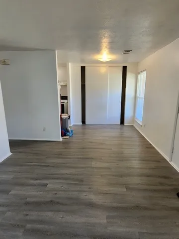 a view of an empty room with wooden floor